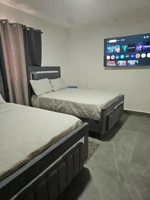 a room with two beds and a tv on the wall at Andys Villa in Naime 3 in San Pedro de Macorís