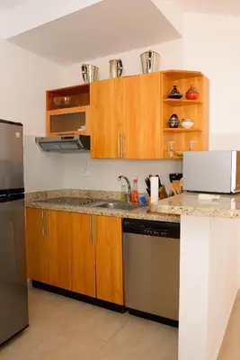 a kitchen with wooden cabinets and a stainless steel refrigerator at 2BR 2BA Beachfront With View 62 in Bayahibe