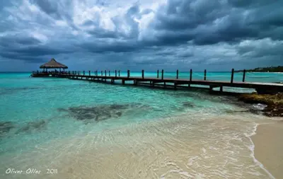 a pier in the water next to a beach at 2BR 2BA Beachfront With View 62 in Bayahibe