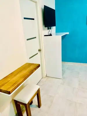a room with a bench and a tv and a stool at Hotel Plaza Coralillo in Sánchez
