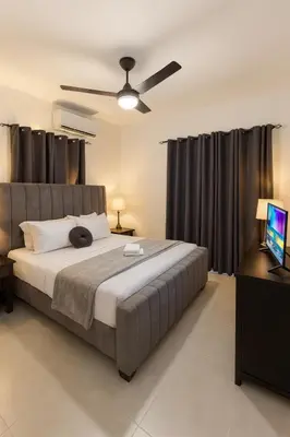 a bedroom with a large bed with black curtains at 2-bedroom apartment with 24h electricity and private parking in Sosúa
