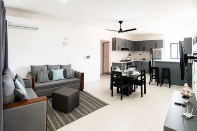 a living room with a couch and a table at 2-bedroom apartment with 24h electricity and private parking in Sosúa