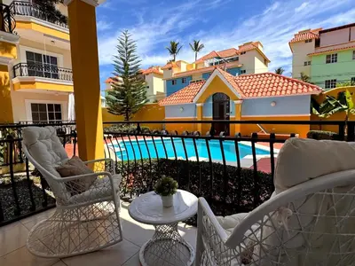 a balcony with chairs and a table and a pool at Backyard, Pool View, Walk to Beach, Dining, Shops in Punta Cana