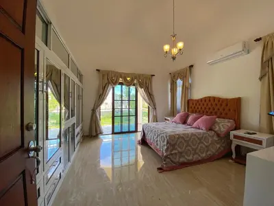 a bedroom with a bed and a large window at Beautiful Villa with Mountain view in San Felipe de Puerto Plata