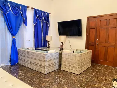 a living room with two wicker chairs and a television at Beautiful Villa with Mountain view in San Felipe de Puerto Plata