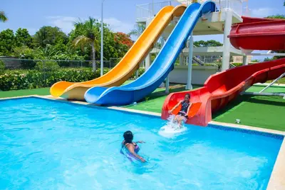 two people on a water slide in a swimming pool at Santa Fe Club in Sosúa