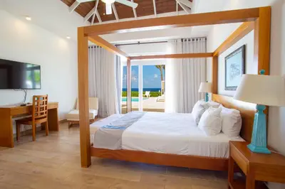 a bedroom with a bed and a desk and a television at Santa Fe Club in Sosúa