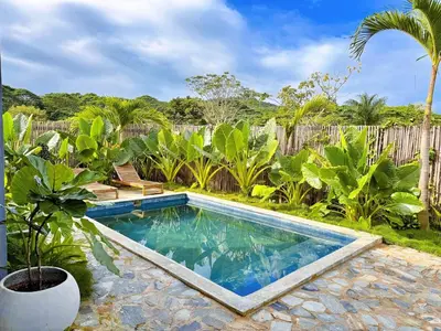 a swimming pool in a yard next to a wooden fence at Casa Ola, luxurious jungle house in El Valle