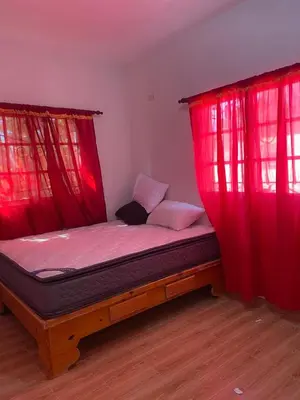 a bed with red curtains in a room at Hotel Mi Propio Esfuerzo in Vicente Noble