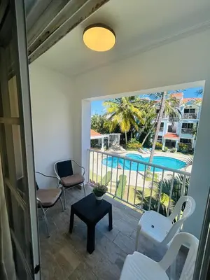 a room with a balcony with a view of a pool at Paradise Arenas De Bávaro RD in Punta Cana