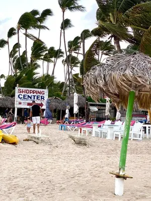 a sign on a beach with chairs and palm trees at Paradise Arenas De Bávaro RD in Punta Cana