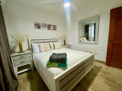 a bedroom with a large bed and a mirror at Paradise Arenas De Bávaro RD in Punta Cana
