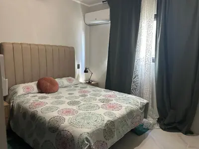 a bedroom with a bed with a flowered blanket and a window at Ester house Sabaneta in Sabaneta