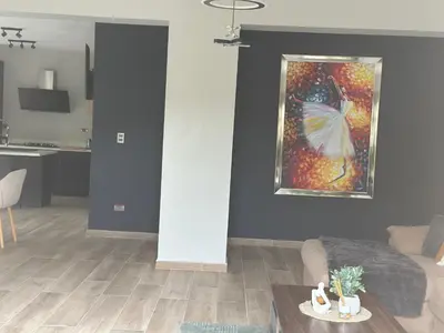 a living room with a butterfly painting on the wall at Ester house Sabaneta in Sabaneta