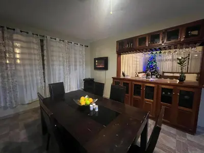 a dining room with a table with chairs and a television at Casa en río san Juan 4 habitaciones in Río San Juan