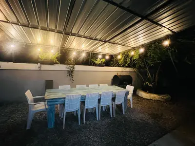 a blue table and chairs in a room with lights at Casa en río san Juan 4 habitaciones in Río San Juan