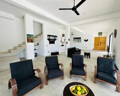 a living room with chairs and a bowl of fruit on a table at Casa Juan Lucas in Las Galeras