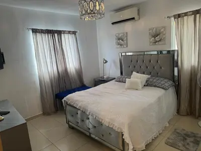 a bedroom with a large bed and a chandelier at Renta Vacacional en el Caribe in Ciruelitos Arriba