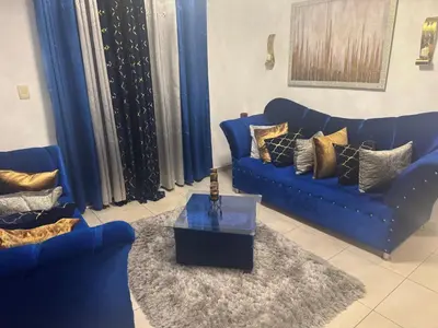 a living room with two blue couches and a table at Renta Vacacional en el Caribe in Ciruelitos Arriba