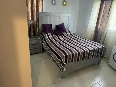 a bed with purple pillows in a bedroom at Renta Vacacional en el Caribe in Ciruelitos Arriba