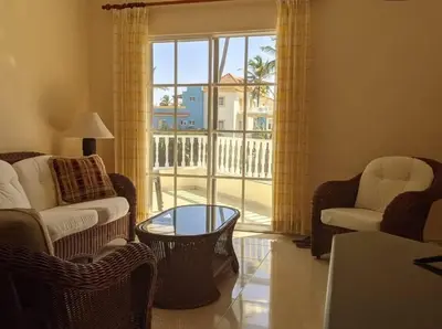 a living room with chairs and a table and a window at Penthouse in El Cortecito in Punta Cana