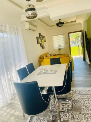 a dining room with a white table and blue chairs at Villas Miranda in La Tentación