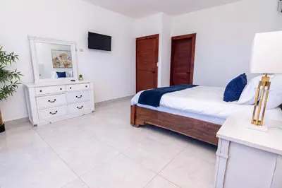 a bedroom with a bed with a dresser and a mirror at Beautiful ocean and mountain view villa in Gaspar Hernández