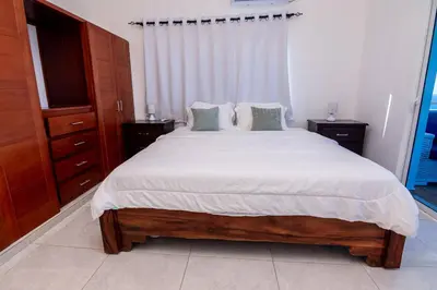 a bedroom with a large bed with white sheets at Beautiful ocean and mountain view villa in Gaspar Hernández