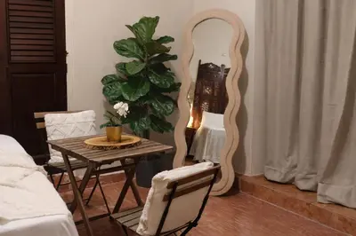 a living room with a table and a mirror at Colonial City Stay with Local Soul in Santo Domingo