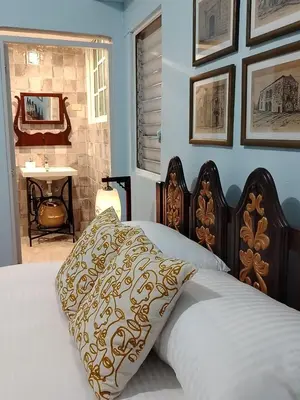 a bed with a pillow on it in a bedroom at Colonial City Stay with Local Soul in Santo Domingo