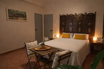 a bedroom with a bed and a table and chairs at Colonial City Stay with Local Soul in Santo Domingo