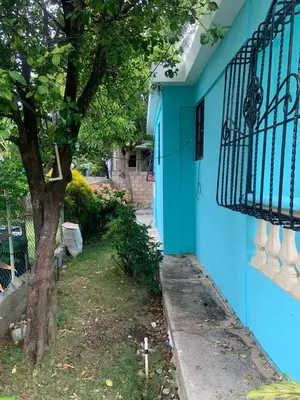 a blue house with a tree and a balcony at Villa francia in Santa Cruz de Barahona