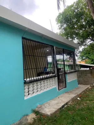 a blue and white house with a window at Villa francia in Santa Cruz de Barahona