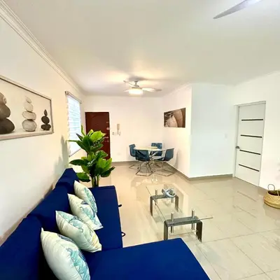 a living room with a blue couch and a table at Central in Punta Cana Beach Life RD in Punta Cana