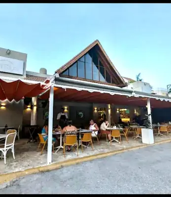 a group of people sitting at tables outside a restaurant at Central in Punta Cana Beach Life RD in Punta Cana