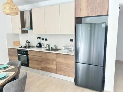 a kitchen with a stainless steel refrigerator next to a table at Caribbean Dream Condo AC WIFI in La Laguna