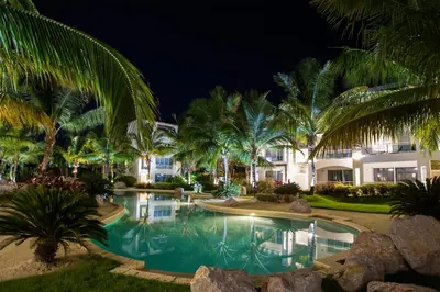 a resort pool at night with palm trees at Caribbean Dream Condo AC WIFI in La Laguna