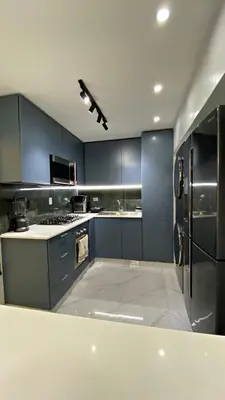 a large kitchen with blue cabinets and appliances at Apartamento in Mendoza