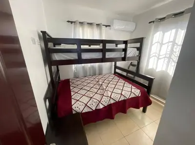 a bedroom with a bunk bed with a red blanket at Villas Hillside apt 1 in Santa Bárbara de Samaná