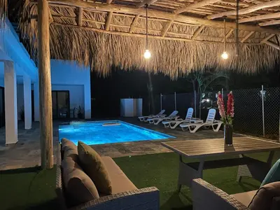 a swimming pool with chairs and a table and a table at Casa Entre Playas - 14 pax, 3 min de la playa en Las Galeras in Las Galeras