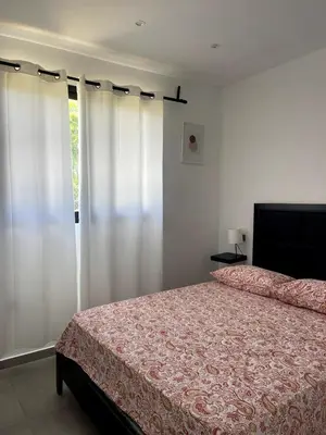 a bedroom with a bed and white curtains at Casa Entre Playas - 14 pax, 3 min de la playa en Las Galeras in Las Galeras