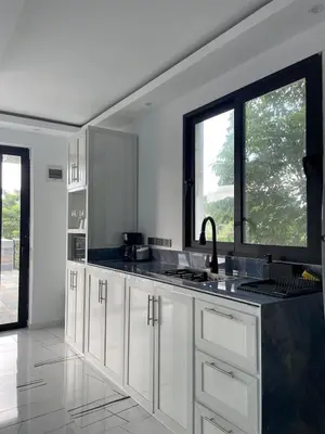 a kitchen with white cabinets and a large window at Casa Entre Playas - 14 pax, 3 min de la playa en Las Galeras in Las Galeras