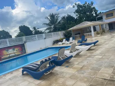 a row of lounge chairs next to a swimming pool at Kasita del sol boca chica in La Caleta