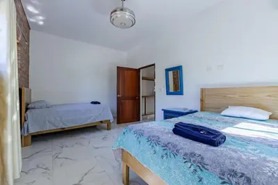 a bedroom with two beds and a suitcase on the bed at Luxurious Home with Pool! in San Felipe de Puerto Plata