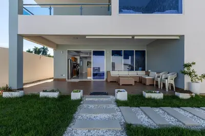 a patio with a couch and chairs in a house at Luxurious Home with Pool! in San Felipe de Puerto Plata