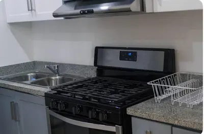a kitchen with a black stove and a sink at Esmeralda modern apartment at Romana del Oeste in La Romana