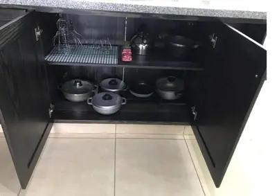 a black kitchen with pots and pans on a shelf at Esmeralda modern apartment at Romana del Oeste in La Romana