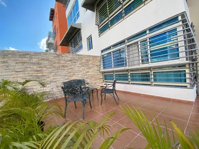 two chairs and a table on a patio in front of a building at Oasis Colonial in Santo Domingo