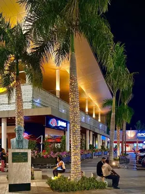 a group of palm trees in front of a shopping center at Oasis Colonial in Santo Domingo