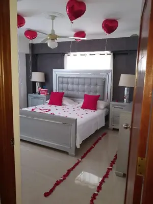 a bedroom with a bed with pink pillows and a ceiling at Oasis Colonial in Santo Domingo